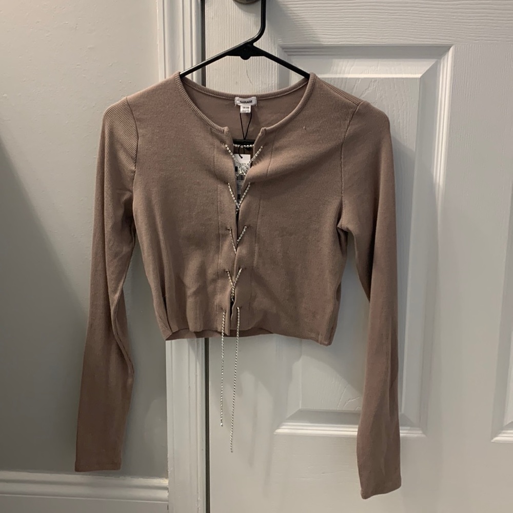 beige top with rhinestone cross at front